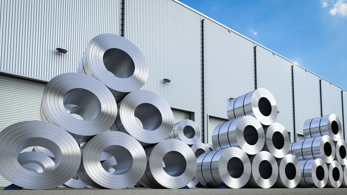 Rolls of steel sheets arranged in pyramids outside a factory